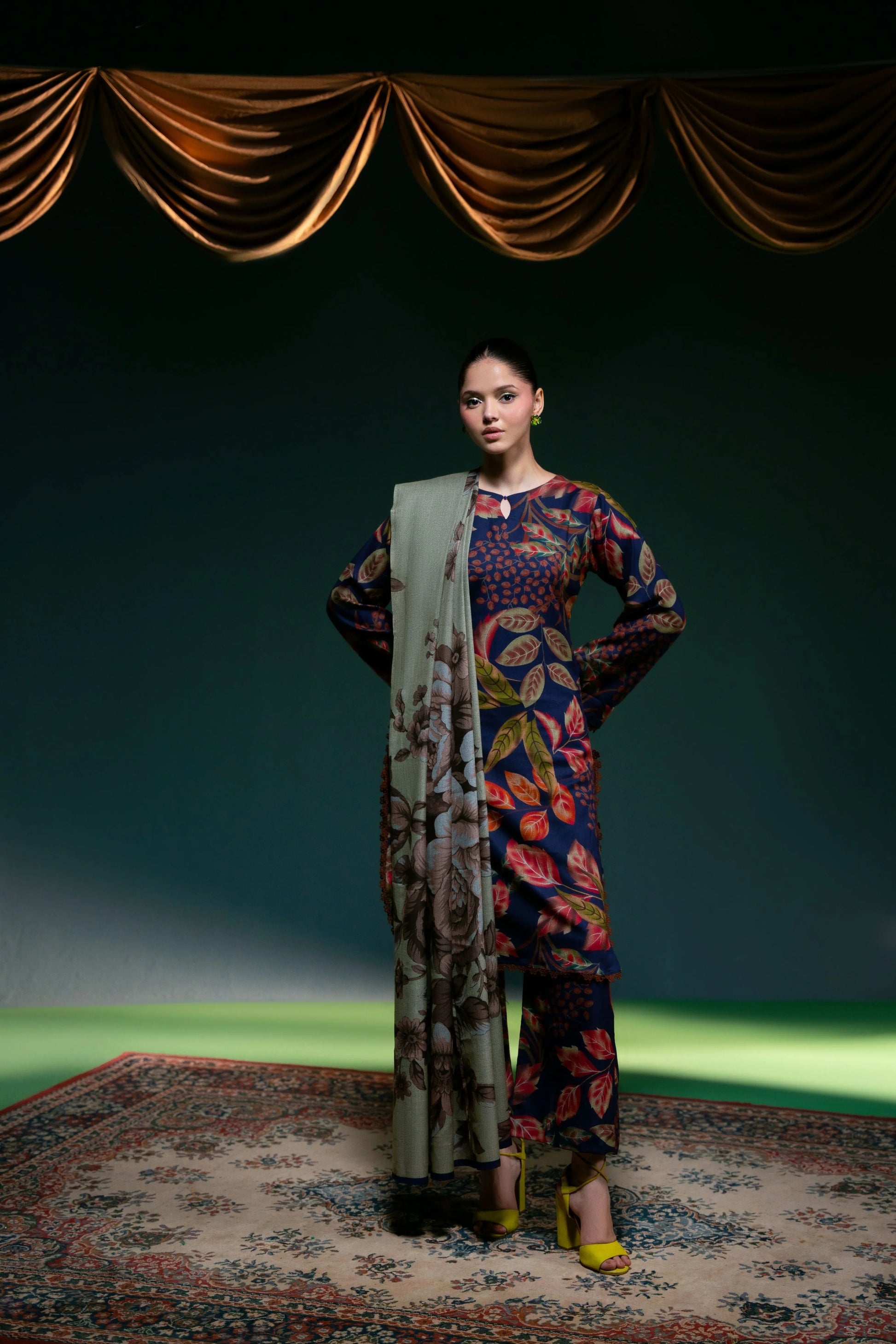 Modèle portant le shalwar kameez Midnight Foliage complet, devant un rideau doré — vue de face.