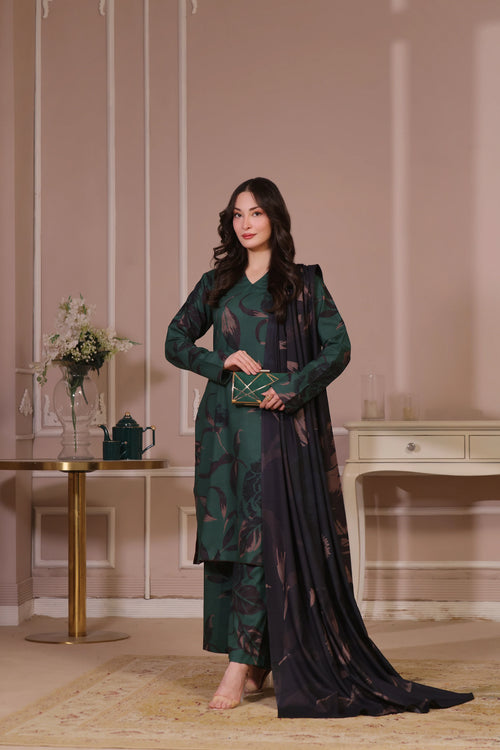 Femme debout de face en shalwar kameez vert forêt Banadora, tenant une pochette dorée.
