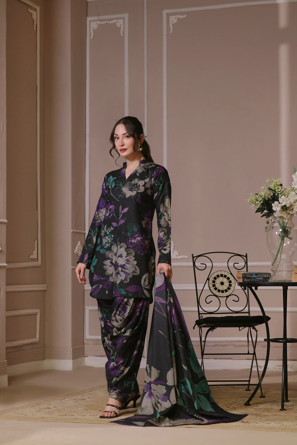 Femme portant un shalwar kameez noir fleuri avec foulard long assorti
