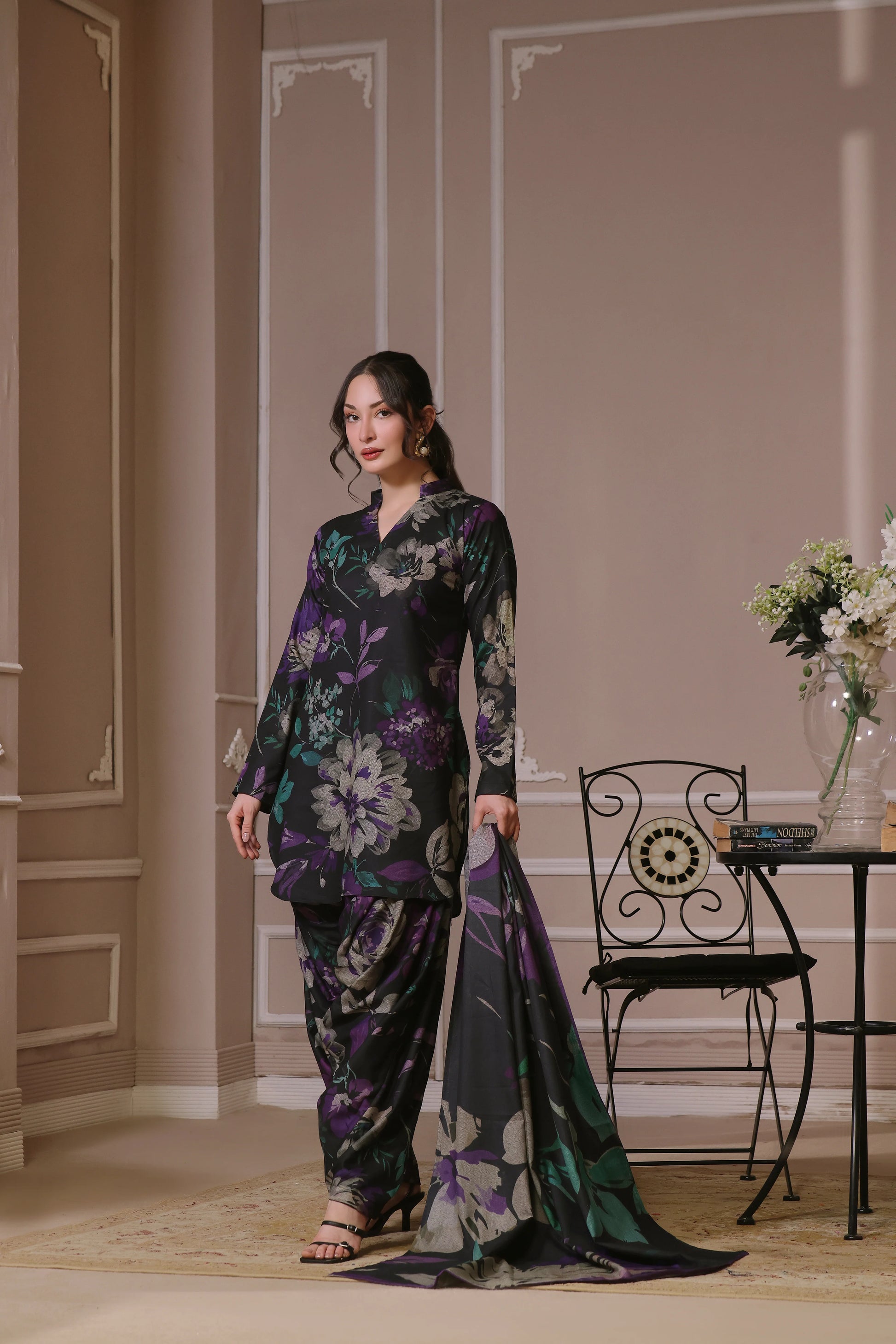 Femme portant un shalwar kameez noir fleuri avec foulard long assorti