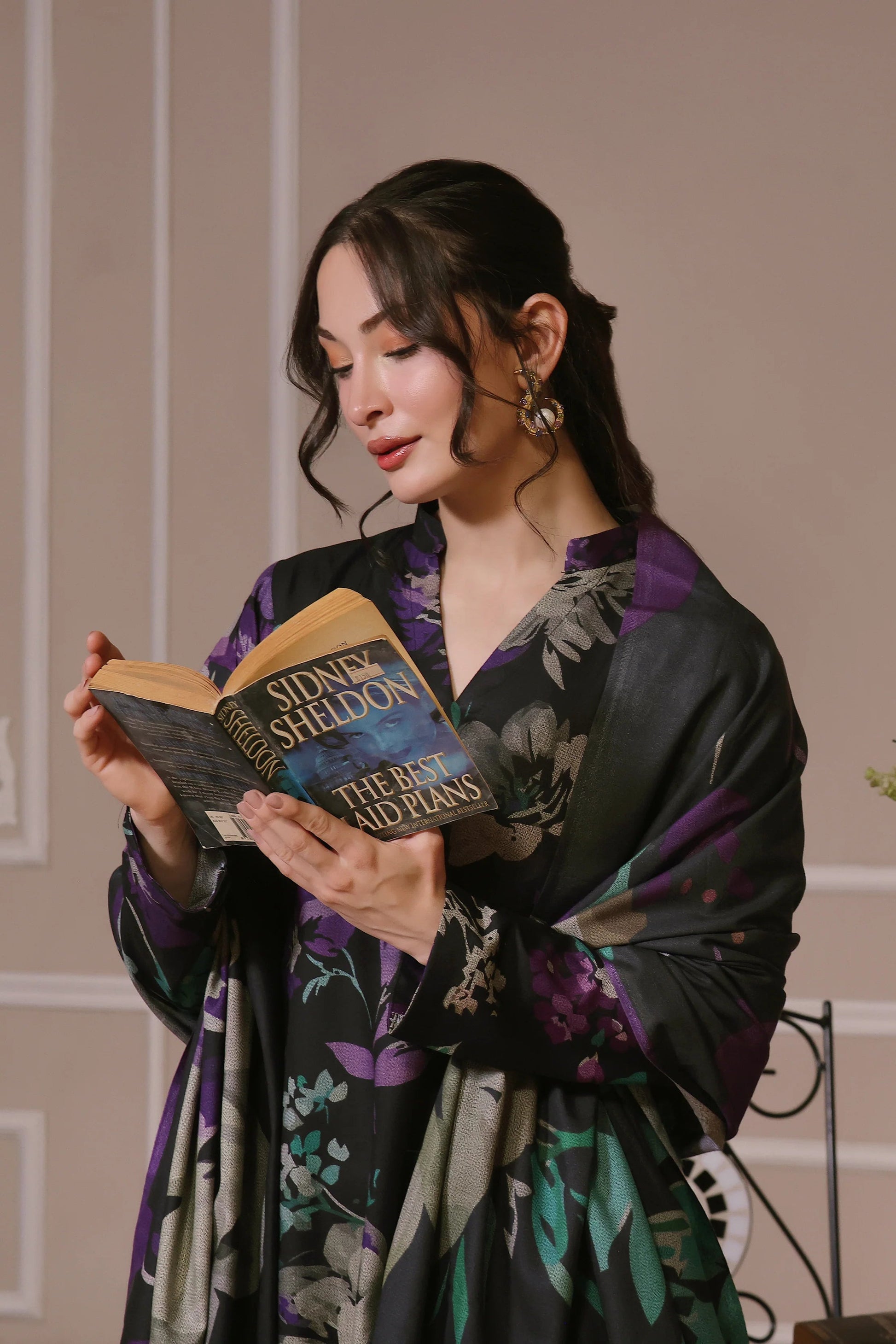 Femme lisant un livre habillée en shalwar kameez noir à fleurs violet