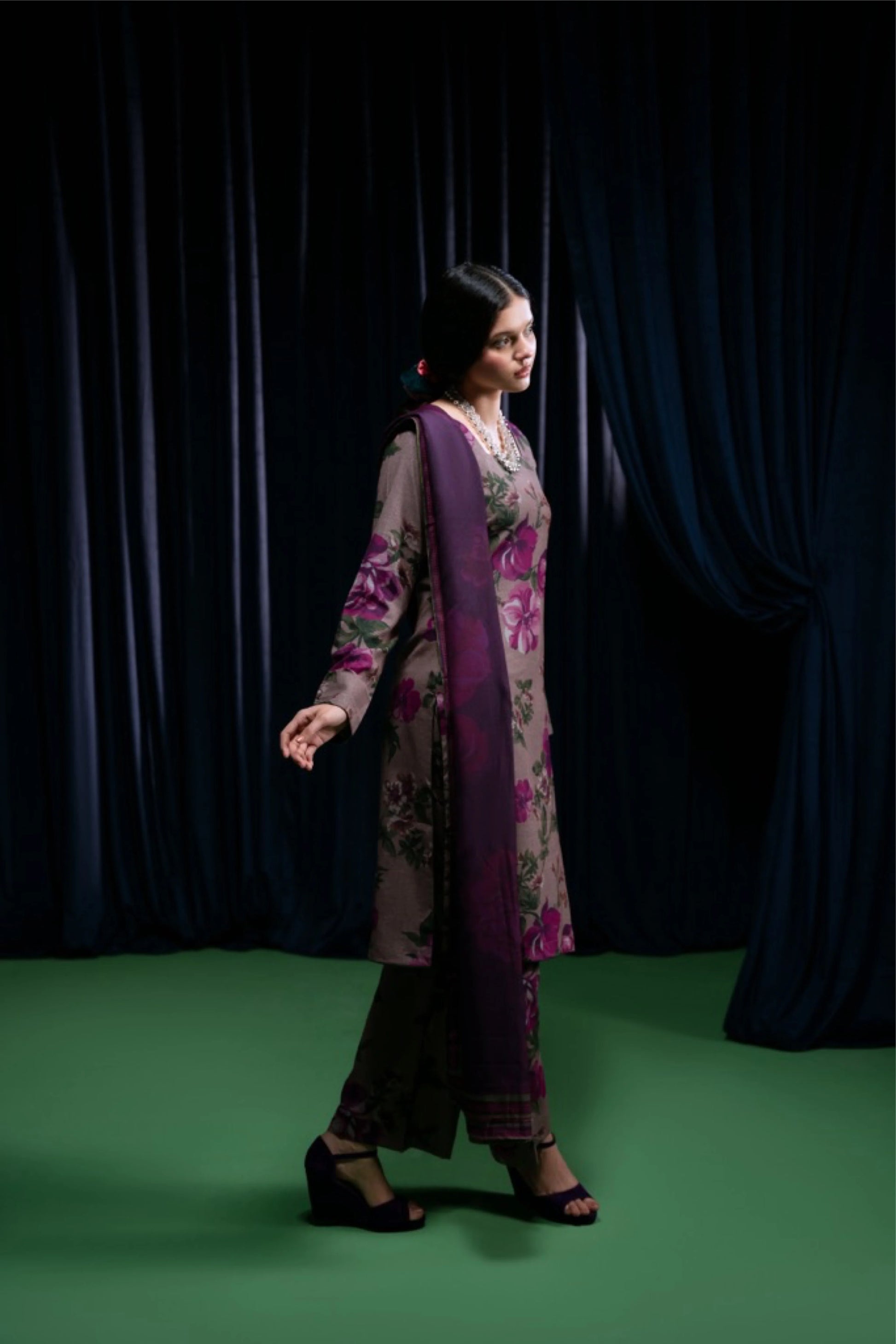 modèle marchant en shalwar prune imprimé floral, fond vert et rideaux