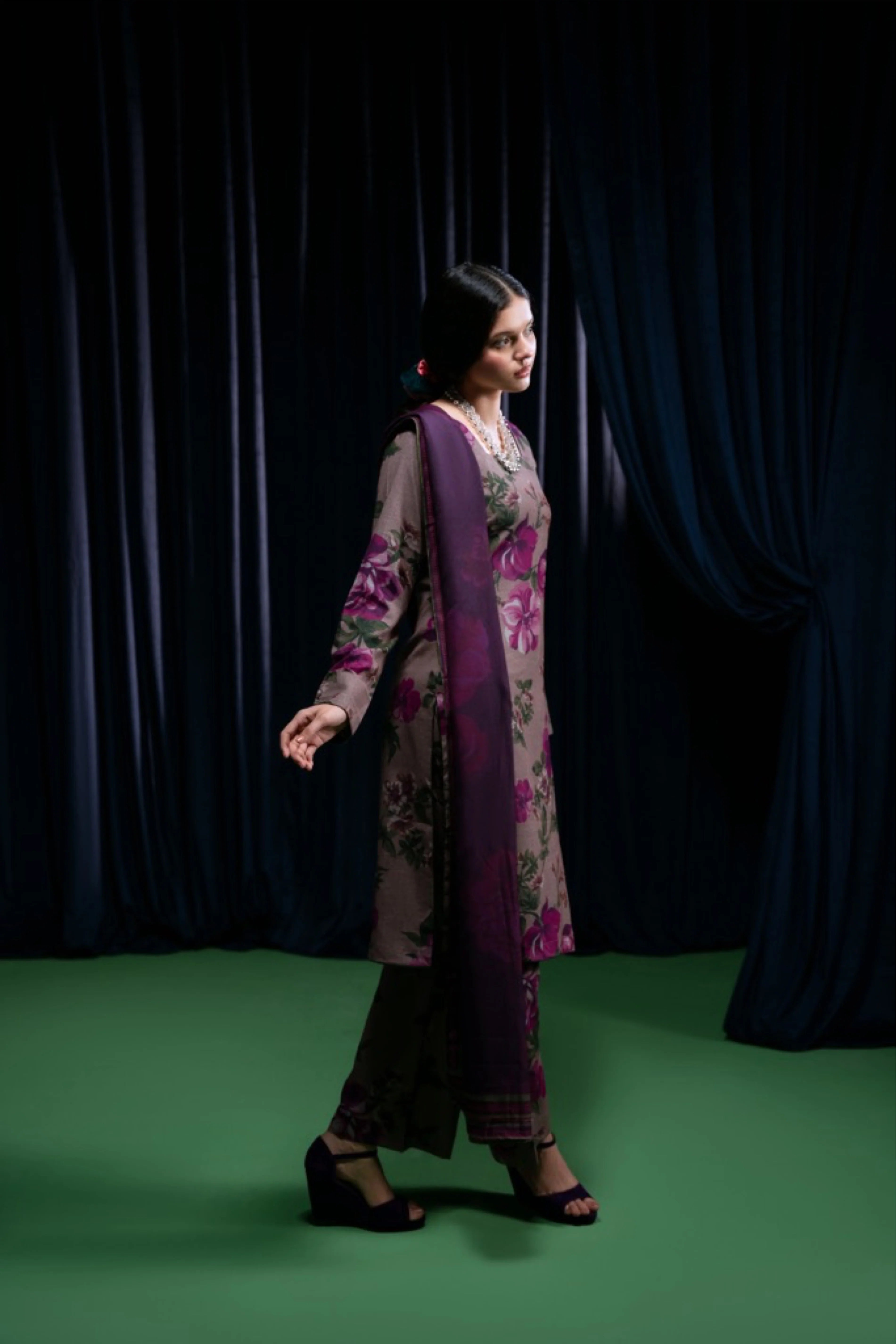modèle marchant en shalwar prune imprimé floral, fond vert et rideaux