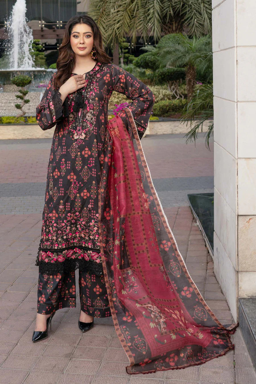 Femme élégante portant des habits pakistanais, shalwar kameez, (ou salwar kameez), habits traditionnels du Pakistan, habits amples, collection printemps été, imprimé en motifs bordeaux et noir, avec un shawl léger (écharpe ou foulard) en linon, en imprimé motif rouge, et un pantalon coupe patte d'éléphant.