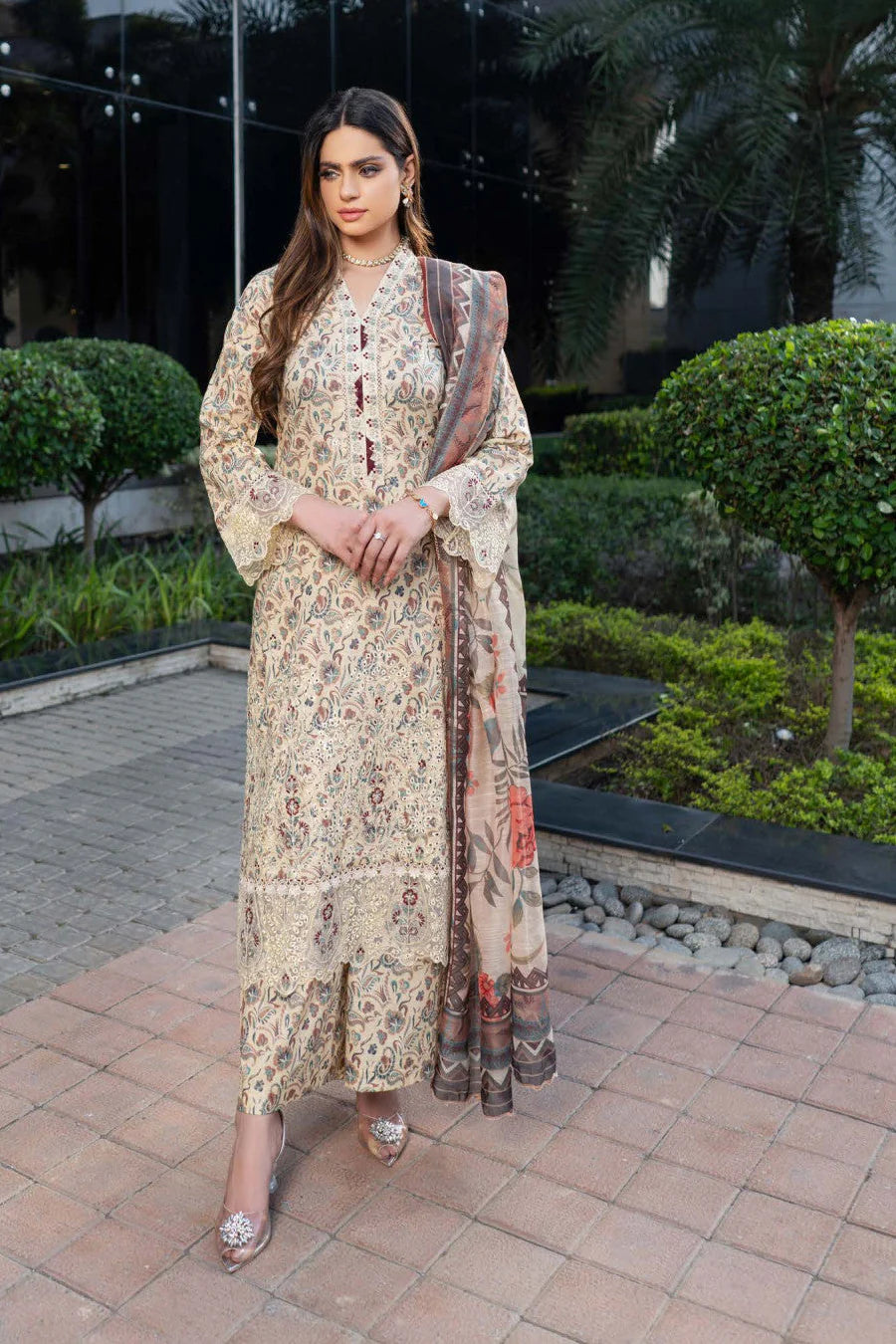 Femme élégante portant des habits pakistanais, shalwar kameez, (ou salwar kameez), habits traditionnels du Pakistan, habits amples, collection printemps été, imprimé en motifs crème et beige, avec un shawl léger (écharpe ou foulard) en linon, en imprimé motif crème, et un pantalon coupe patte d'éléphant.