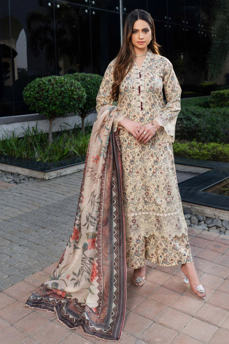 Femme élégante portant des habits pakistanais, shalwar kameez, (ou salwar kameez), habits traditionnels du Pakistan, habits amples, collection printemps été, imprimé en motifs crème et beige, avec un shawl léger (écharpe ou foulard) en linon, en imprimé motif crème, et un pantalon coupe patte d'éléphant.