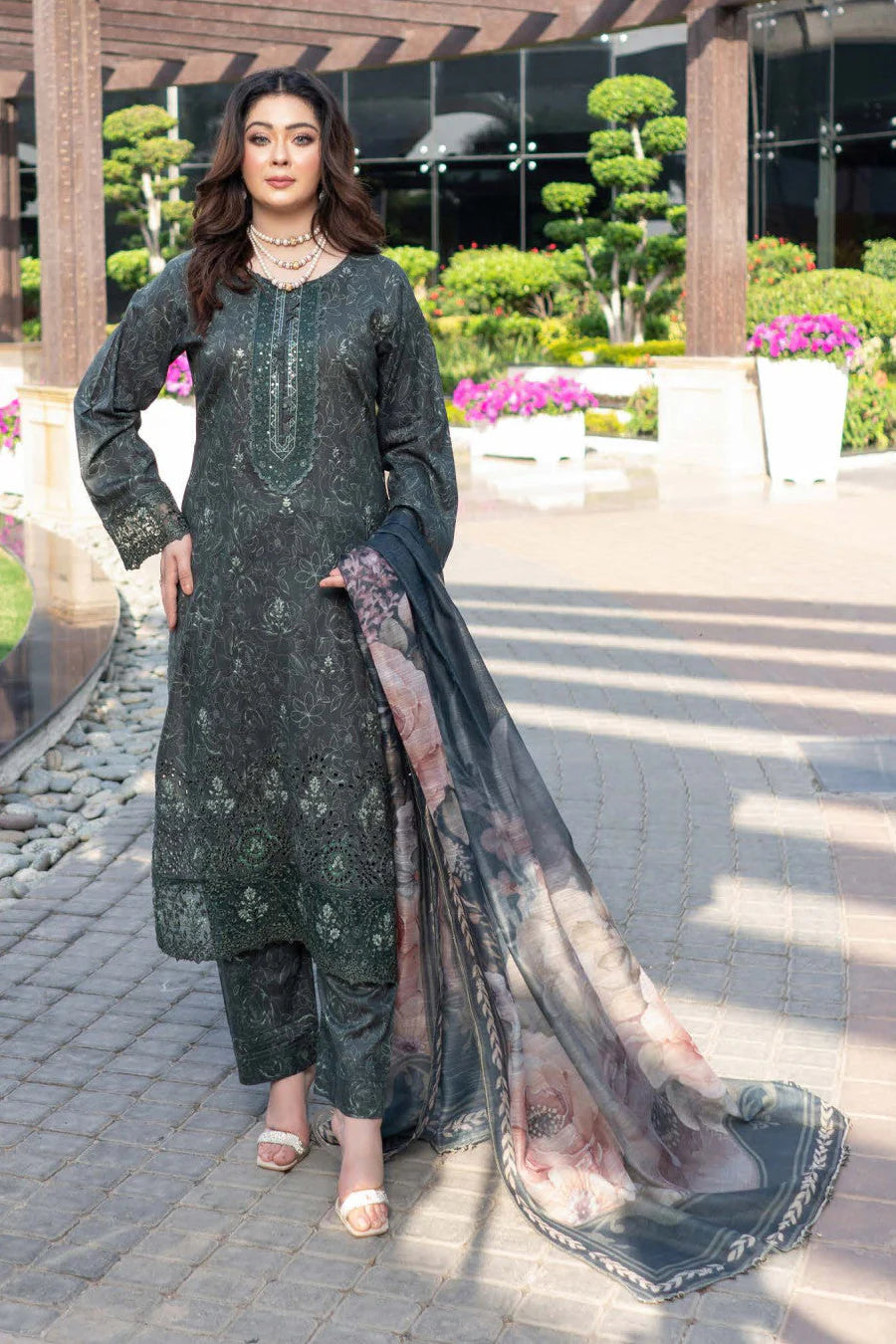 Femme élégante portant des habits pakistanais, shalwar kameez, (ou salwar kameez), habits traditionnels du Pakistan, habits amples, collection printemps été, imprimé en motifs émeraude et noir, avec un châle léger (écharpe ou foulard) en linon, en imprimé motif émeraude, et un pantalon coupe patte d'éléphant.