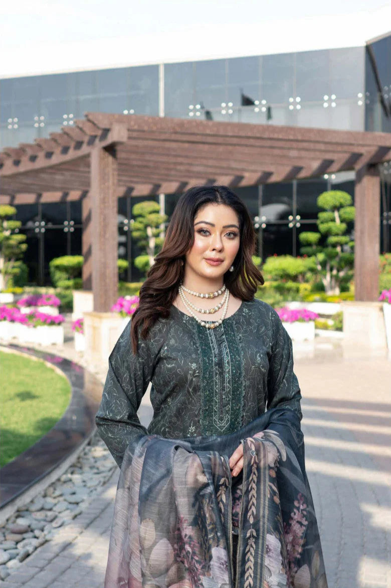 Femme élégante portant des habits pakistanais, shalwar kameez, (ou salwar kameez), habits traditionnels du Pakistan, habits amples, collection printemps été, imprimé en motifs émeraude et noir, avec un châle léger (écharpe ou foulard) en linon, en imprimé motif émeraude, et un pantalon coupe patte d'éléphant.