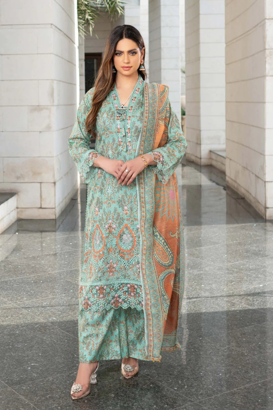 Femme élégante portant des habits pakistanais, shalwar kameez, (ou salwar kameez), habits traditionnels du Pakistan, habits amples, collection printemps été, imprimé en motifs turquoise et orange, avec un shawl léger (écharpe ou foulard) en linon, en imprimé motif turquoise, et un pantalon coupe patte d'éléphant.