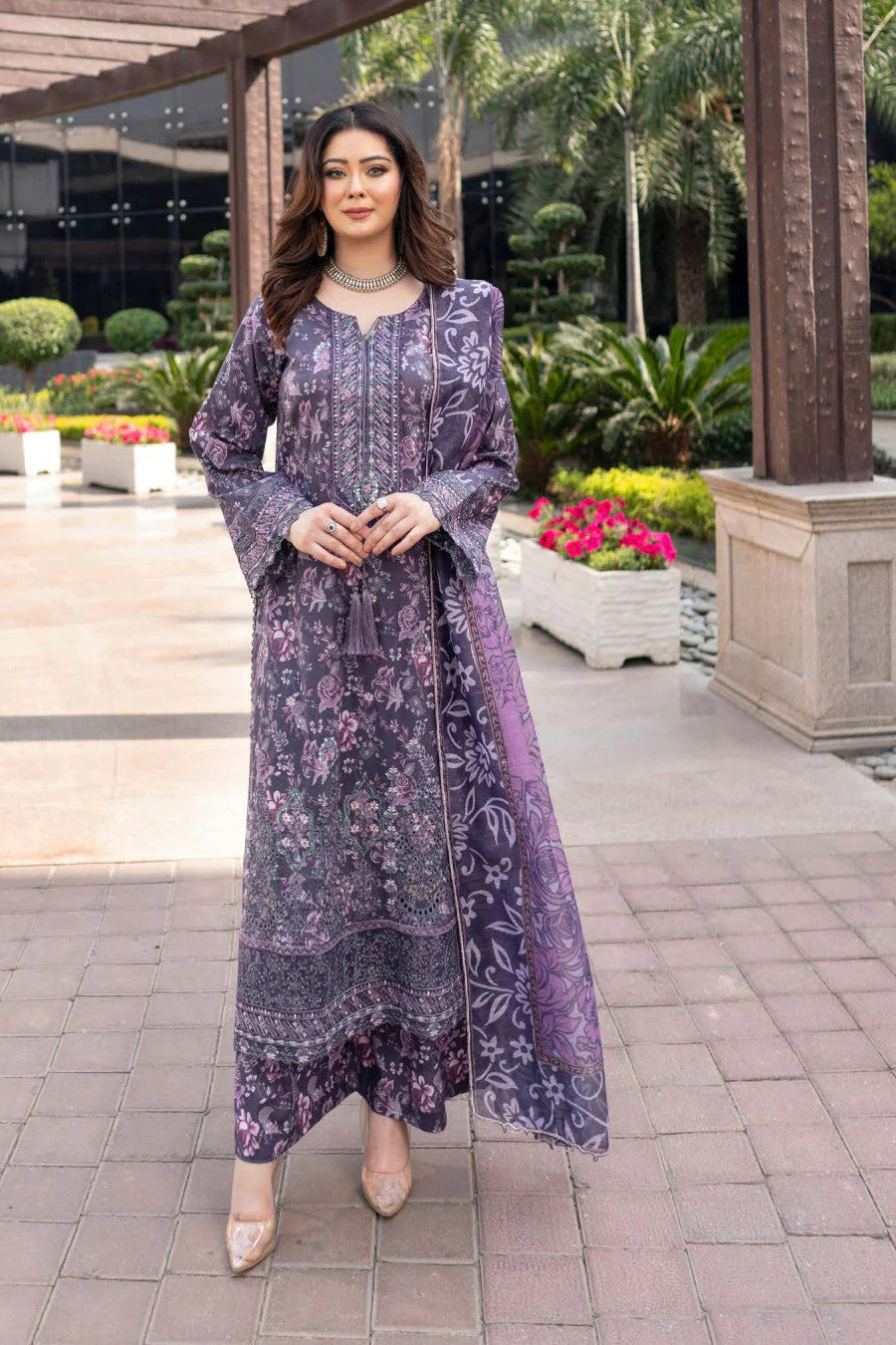 Femme élégante portant des habits pakistanais, shalwar kameez, (ou salwar kameez), habits traditionnels du Pakistan, habits amples, collection printemps été, imprimé en motifs violet et rose, avec un shawl léger (écharpe ou foulard) en linon, en imprimé motif violet, et un pantalon coupe patte d'éléphant.
