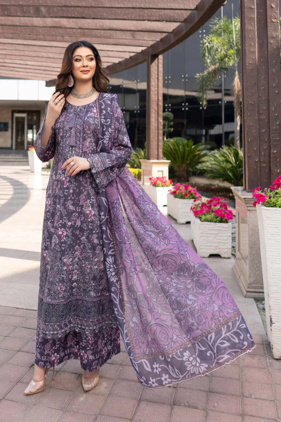 Femme élégante portant des habits pakistanais, shalwar kameez, (ou salwar kameez), habits traditionnels du Pakistan, habits amples, collection printemps été, imprimé en motifs violet et rose, avec un shawl léger (écharpe ou foulard) en linon, en imprimé motif violet, et un pantalon coupe patte d'éléphant.